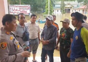 Naiki Perahu Motor, Polsek Siak Hulu Bantu Warga Terdampak Banjir Sekaligus Cooling System Pemilu Damai