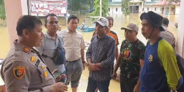Naiki Perahu Motor, Polsek Siak Hulu Bantu Warga Terdampak Banjir Sekaligus Cooling System Pemilu Damai